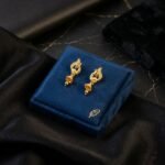 Gold Peacock Drop Earrings with Jhumka-style Accents.